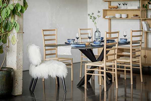 Dining table with black metal legs and 6 black wooden chairs.